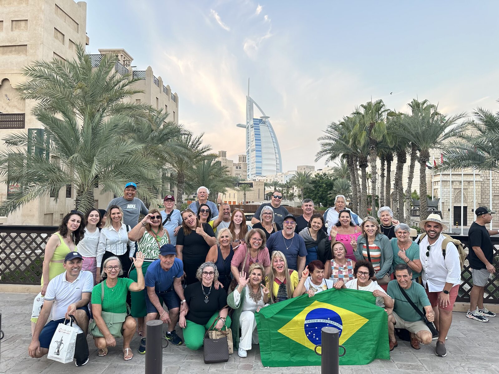 Grupo Rigue em frente ao Burj Al Arab com a bandeira do Brasil